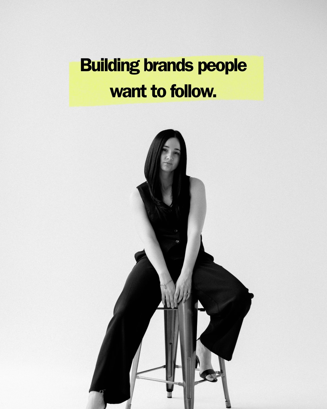 Dani seated on a metal stool beneath the words: Building brands people want to follow.